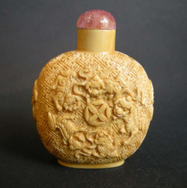 Ivory snuff bottle sculpted with 9 Fo Dogs
